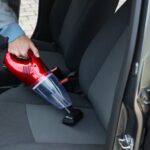 Handstaubsauger reinigt Autositz