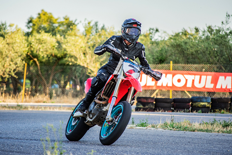 Eine Person mit einem Motorrad-Kombi auf einem Crossbike