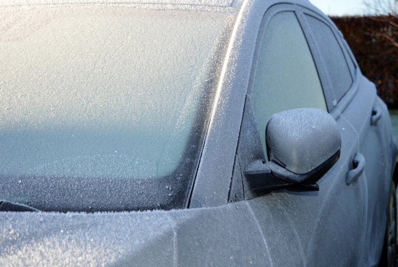 Ein zugefrorenes Auto muss vor dem Gebrauch erst vollständig enteist werden mit einem Eiskratzer 